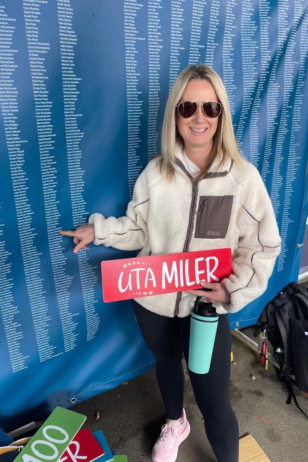 Meg with the UTA Miler sign after her 100 mile ultra