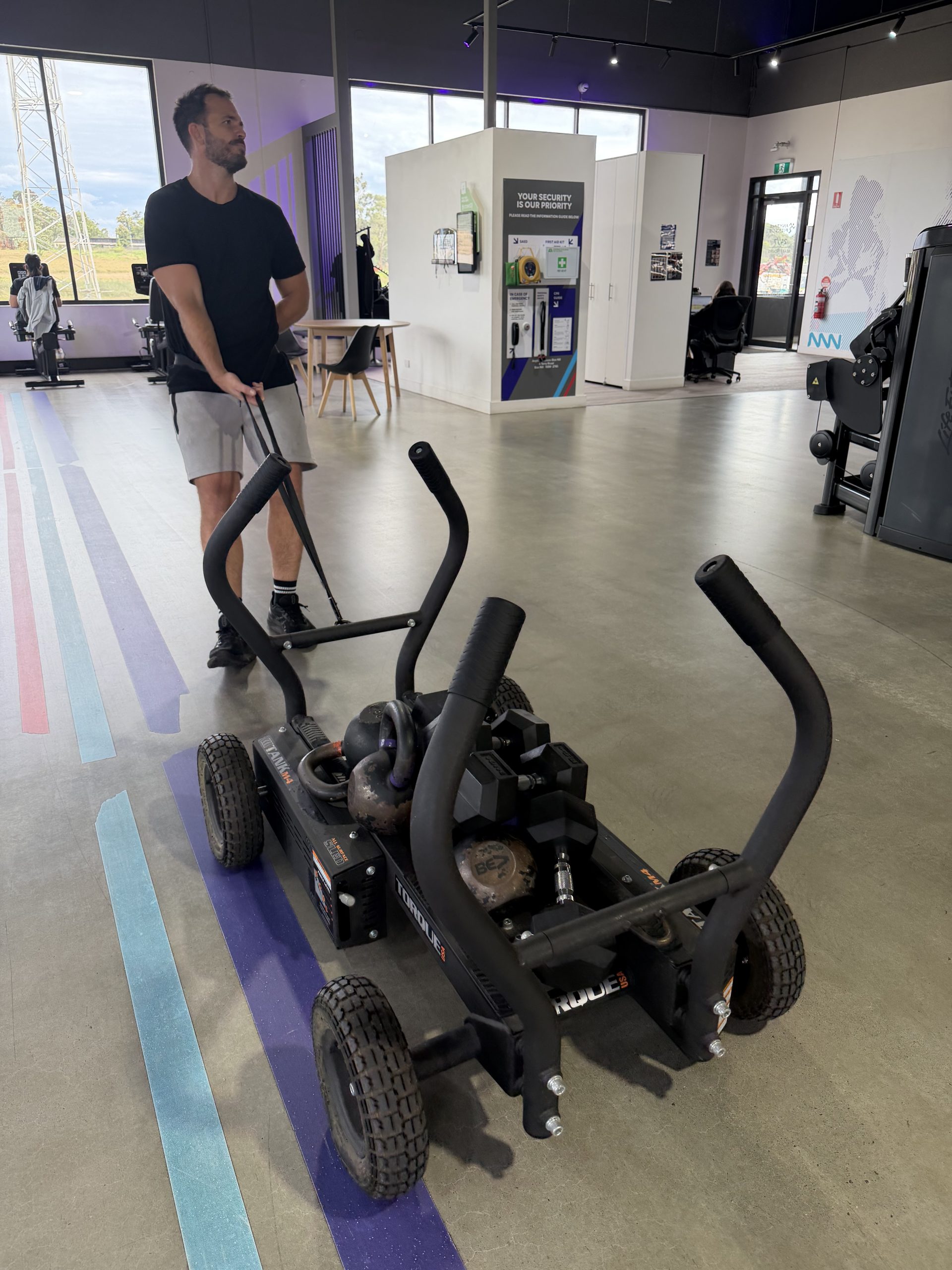Brad pushing a loaded sled across the gym floor