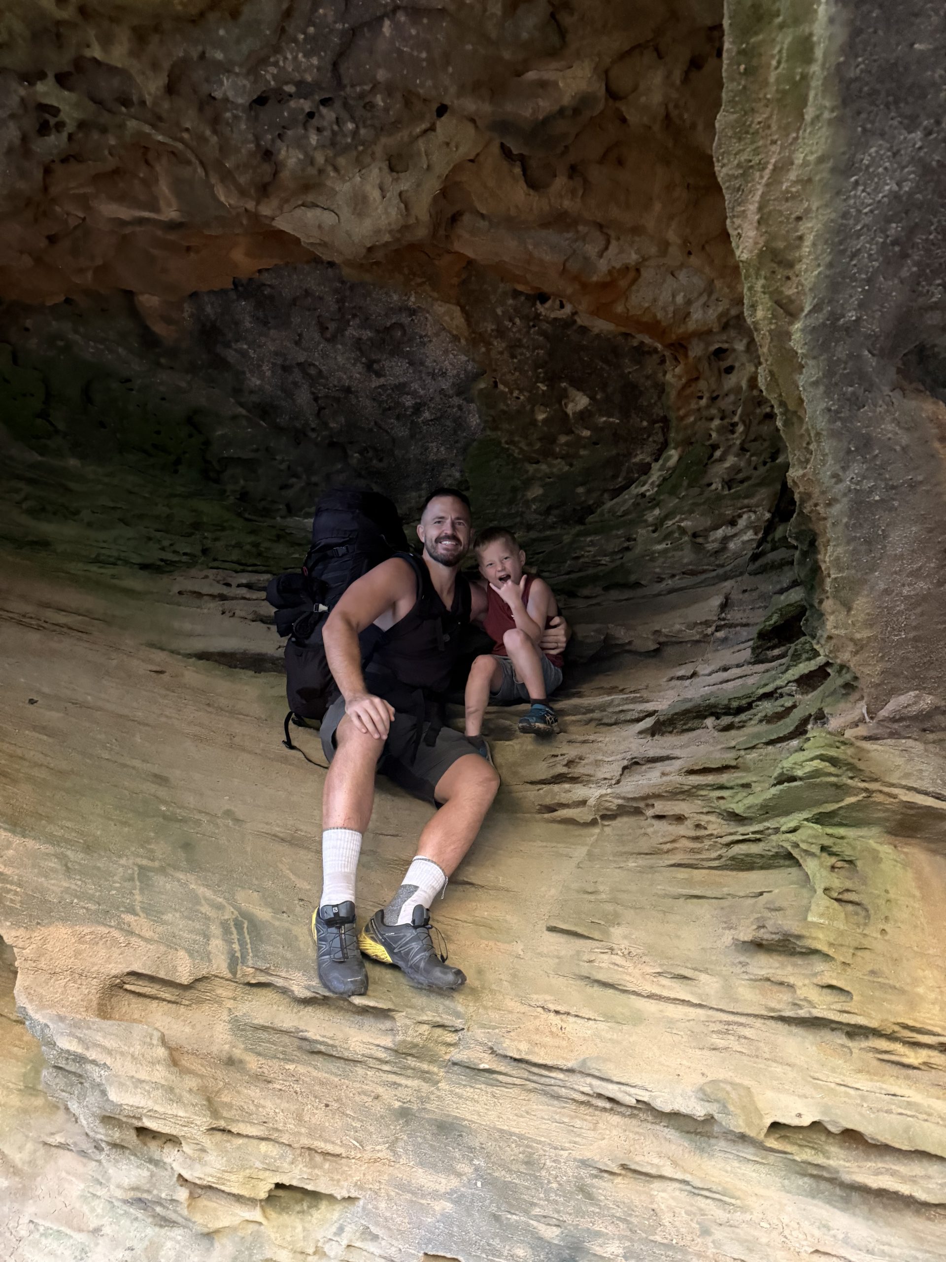 Brad and Nathan sitting on a rock ledge partway in