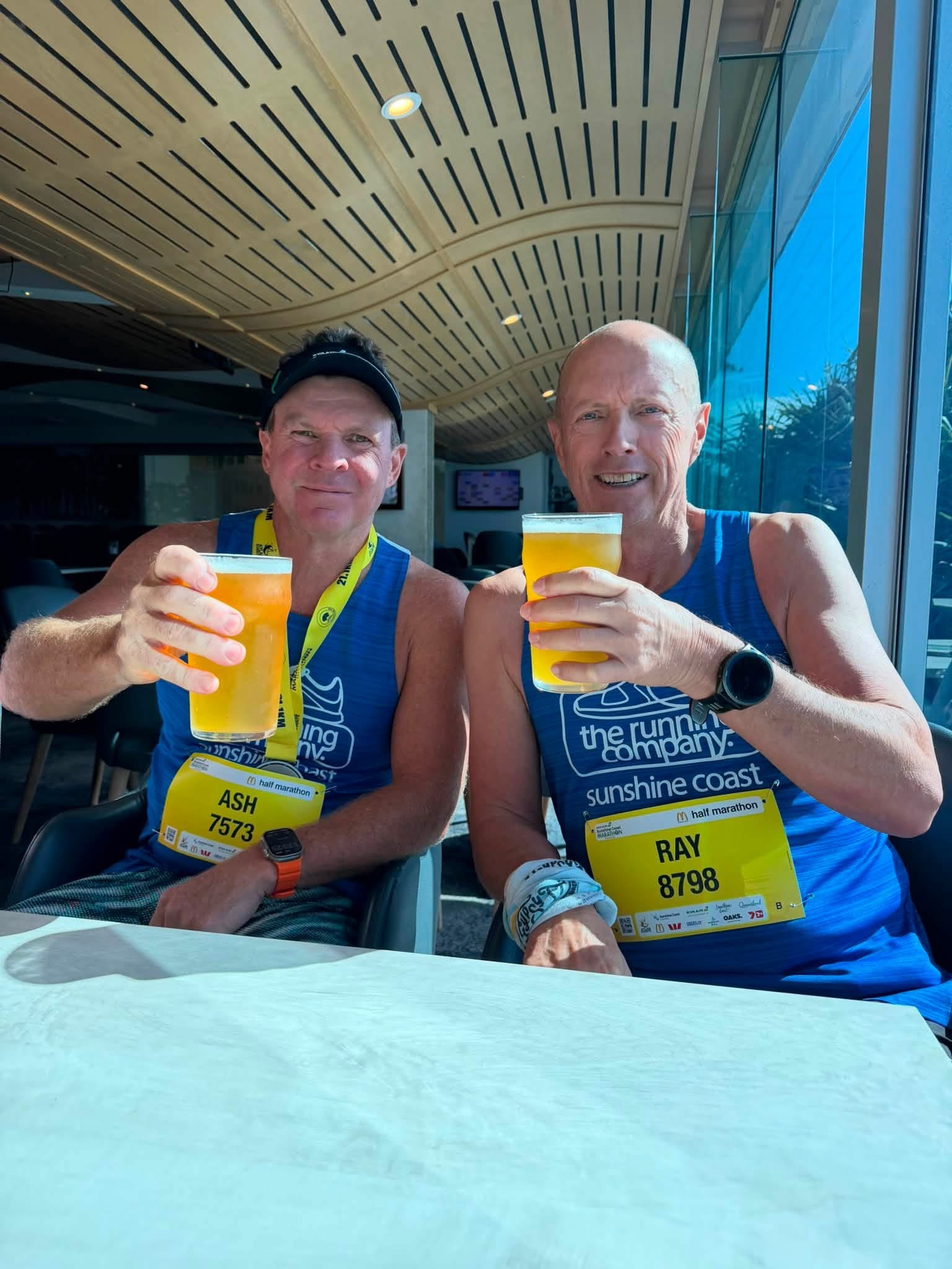 Two runners with a drink after finishing a race