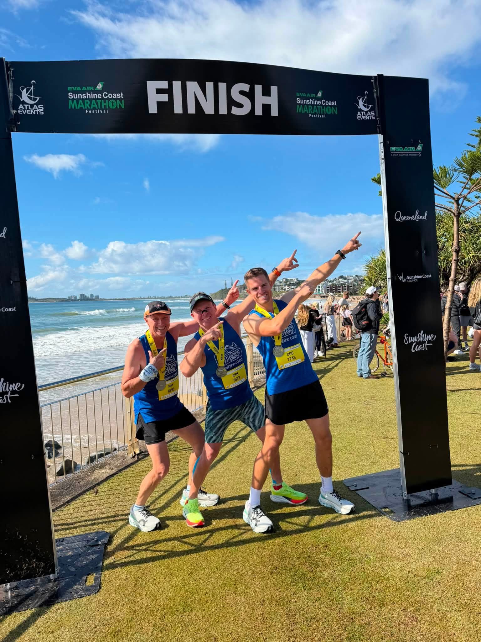 A group of runners celebrating under the finish arch